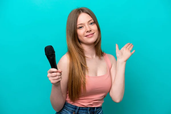 Kafkasyalı Şarkıcı Mavi Arka Planda Izole Edilmiş Bir Mikrofonu Kaldırıyor — Stok fotoğraf