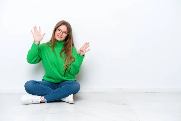 Mladý Běloška Žena Sedí Podlaze Izolované Bílém Pozadí Napočítání Devět — Stock fotografie