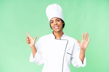 Young African American chef over isolated chroma key background counting seven with fingers