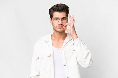 İzole edilmiş beyaz arka planda yakışıklı beyaz bir adam sessizlik işareti gösteriyor.