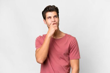 Young handsome caucasian man over isolated white background having doubts and with confuse face expression