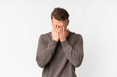 İzole edilmiş beyaz arka planı olan yakışıklı beyaz adam yorgun ve hasta bir ifadeye sahip.