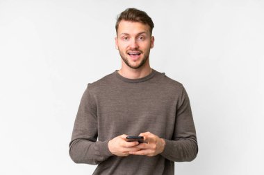 İzole edilmiş beyaz geçmişi olan yakışıklı beyaz bir adam şaşırdı ve bir mesaj gönderiyor.