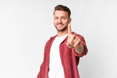 İzole edilmiş beyaz arka planı olan yakışıklı beyaz bir adam parmağını kaldırıyor ve gösteriyor.