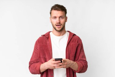 İzole edilmiş beyaz geçmişi olan yakışıklı beyaz bir adam şaşırdı ve bir mesaj gönderiyor.