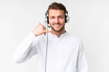 Tele pazarlamacı beyaz bir kulaklıkla çalışan beyaz bir adam telefon jesti yapıyor. Bana geri dönüş işareti ver.