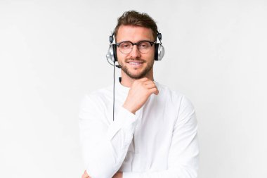 Tele pazarlamacı beyaz kulaklıklı, gözlüklü ve gülümseyen bir adam.