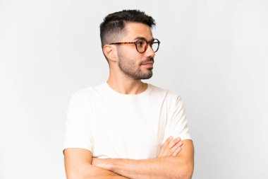 İzole edilmiş beyaz arka planı olan yakışıklı beyaz bir adam kollarını kavuşturuyor.