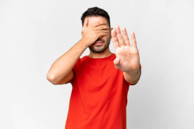 Young handsome caucasian man over isolated white background making stop gesture and covering face