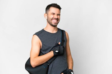 Young sport caucasian man with sport bag over over isolated white background laughing in lateral position