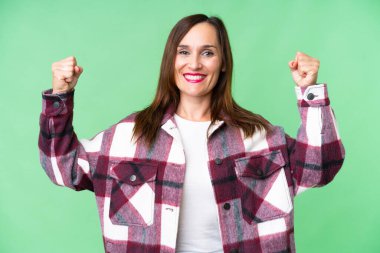Middle age woman over isolated chroma key background doing strong gesture
