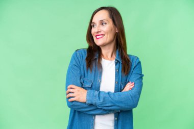 Middle age woman over isolated chroma key background looking side