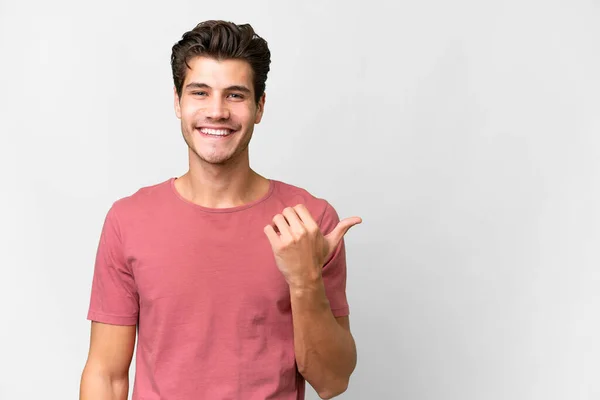 stock image Young handsome caucasian man over isolated white background pointing to the side to present a product