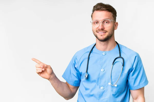 Jonge Verpleegkundige Man Geïsoleerde Witte Achtergrond Wijzende Vinger Naar Zijkant — Stockfoto