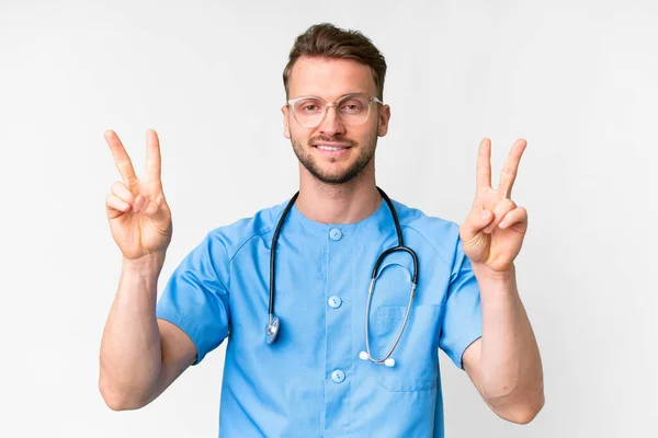 Junger Krankenpfleger Vor Isoliertem Weißem Hintergrund Der Mit Beiden Händen — Stockfoto