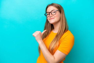 Mavi arka planda soyutlanmış, gururlu ve kendini beğenmiş beyaz bir kadın.