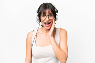 Tele pazarlamacı Kafkasyalı kadın tecrit edilmiş bir arka planda şaşırtıcı ve şok olmuş bir yüz ifadesiyle çalışıyor.