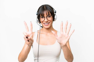 Telemarketer caucasian woman working with a headset over isolated background counting seven with fingers