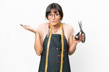Young caucasian seamstress over isolated white background having doubts while raising hands