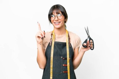 İzole edilmiş beyaz arka plan üzerinde genç beyaz terzi harika bir fikre işaret ediyor.