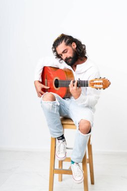 Young man with beard playing guitar on white background