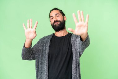 Young man with beard over isolated chroma key background counting nine with fingers
