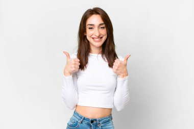 Young caucasian woman over isolated white background with thumbs up gesture and smiling