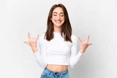 Young caucasian woman over isolated white background making horn gesture