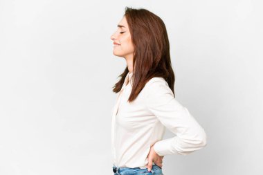 İzole edilmiş beyaz arka planda genç beyaz bir kadın gayret gösterdiği için sırt ağrısı çekiyor.