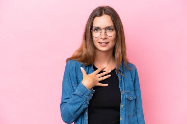 Pembe arka planda izole edilmiş genç beyaz kadın kendini işaret ediyor.