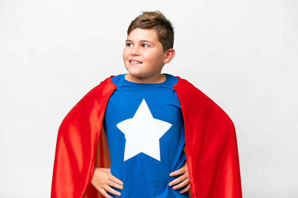Super Hero caucasian kid over isolated white background posing with arms at hip and smiling