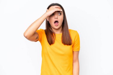 Beyaz arka planda izole edilmiş genç beyaz kadın yan tarafa bakarken sürpriz jest yapıyor.