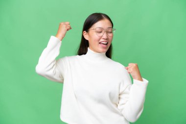 Asyalı genç bir kadın tecrit edilmiş arka planda bir ilan vermek için kopyalama alanı tutuyor.