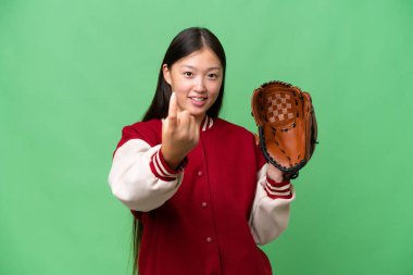 Young asian woman with baseball glove over isolated background doing coming gesture