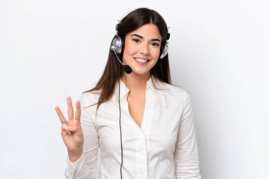 Telemarketer caucasian woman working with a headset isolated on white background happy and counting three with fingers