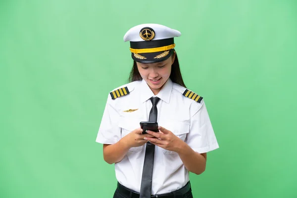 Airplane Pilot Asian Woman Isolated Background Sending Message Mobile — 스톡 사진