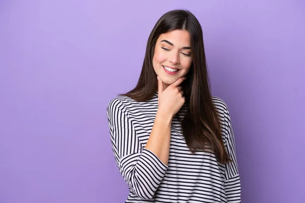 Young Brazilian woman isolated on purple background looking to the side and smiling