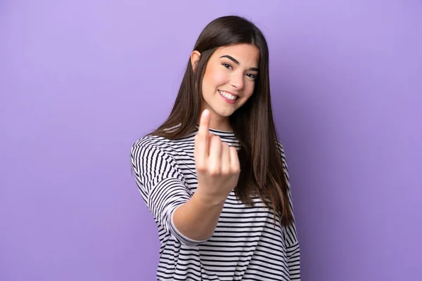Young Brazilian woman isolated on purple background doing coming gesture