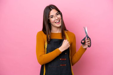 Young Brazilian seamstress woman isolated on pink background celebrating a victory