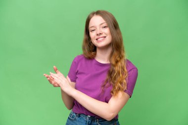 Genç ve güzel bir kadın izole edilmiş arka planda alkışlıyor.