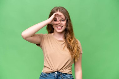 İzole edilmiş arka planda genç ve güzel bir kadın parmaklarıyla işaret veriyor.