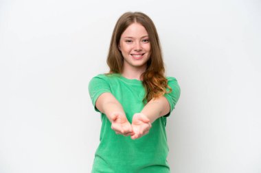 Beyaz arka planda izole edilmiş genç ve güzel bir kadın bir ilan vermek için avucunun içinde hayali bir alan tutuyor.