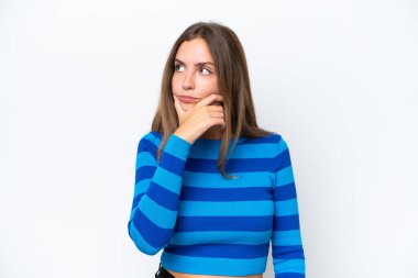 Beyaz arka planda izole edilmiş genç beyaz bir kadın. Şüpheleri var ve kafası karışmış bir yüz ifadesi var.