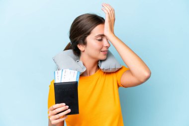 Young beautiful woman with Inflatable travel Pillow isolated on blue background has realized something and intending the solution