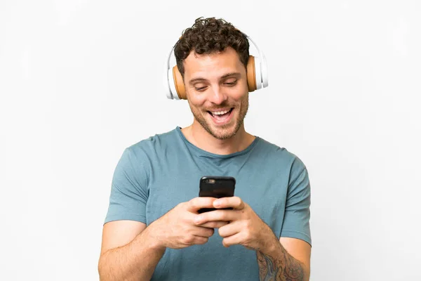 Νεαρός Άνδρας Ακουστικά Και Smartphone Γκρι Φόντο — Φωτογραφία Αρχείου
