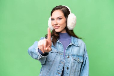 İzole edilmiş arka planda kışlık kuklalar takan beyaz bir kadın parmak kaldırıyor.