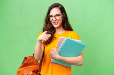 Tecrit edilmiş geçmişi olan genç beyaz kadın şaşırmış ve ön tarafı işaret ediyor.