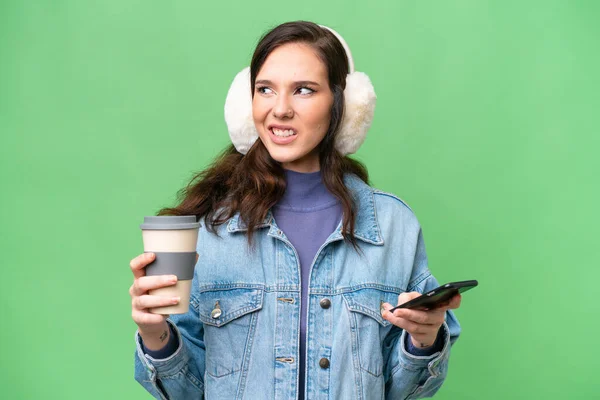 Young Caucasian Woman Wearing Winter Muffs Isolated Background Holding Coffee — Photo