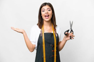 Seamstress woman over isolated white background with shocked facial expression