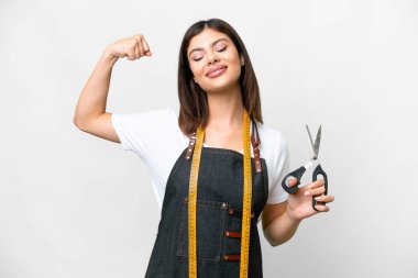 Seamstress woman over isolated white background doing strong gesture